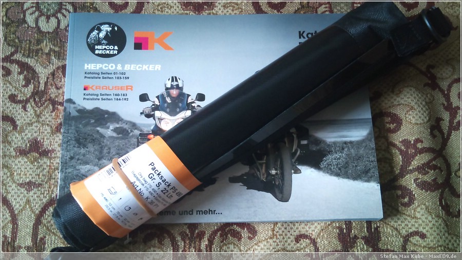 {ops} zusammengerollter Packsack